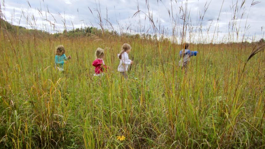 children frolic in the prairie at Pine Point Park