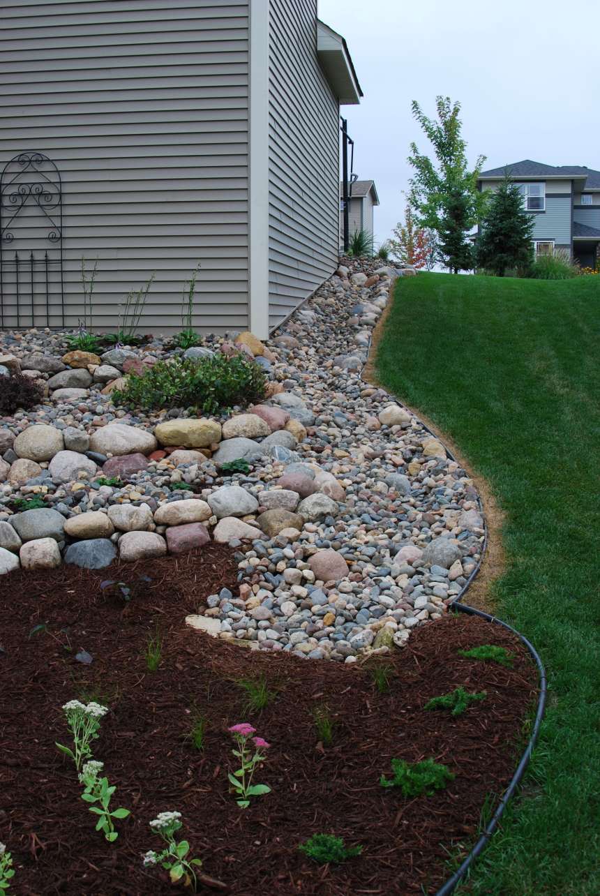 Dry creek and raingarden used to redirect water around a home